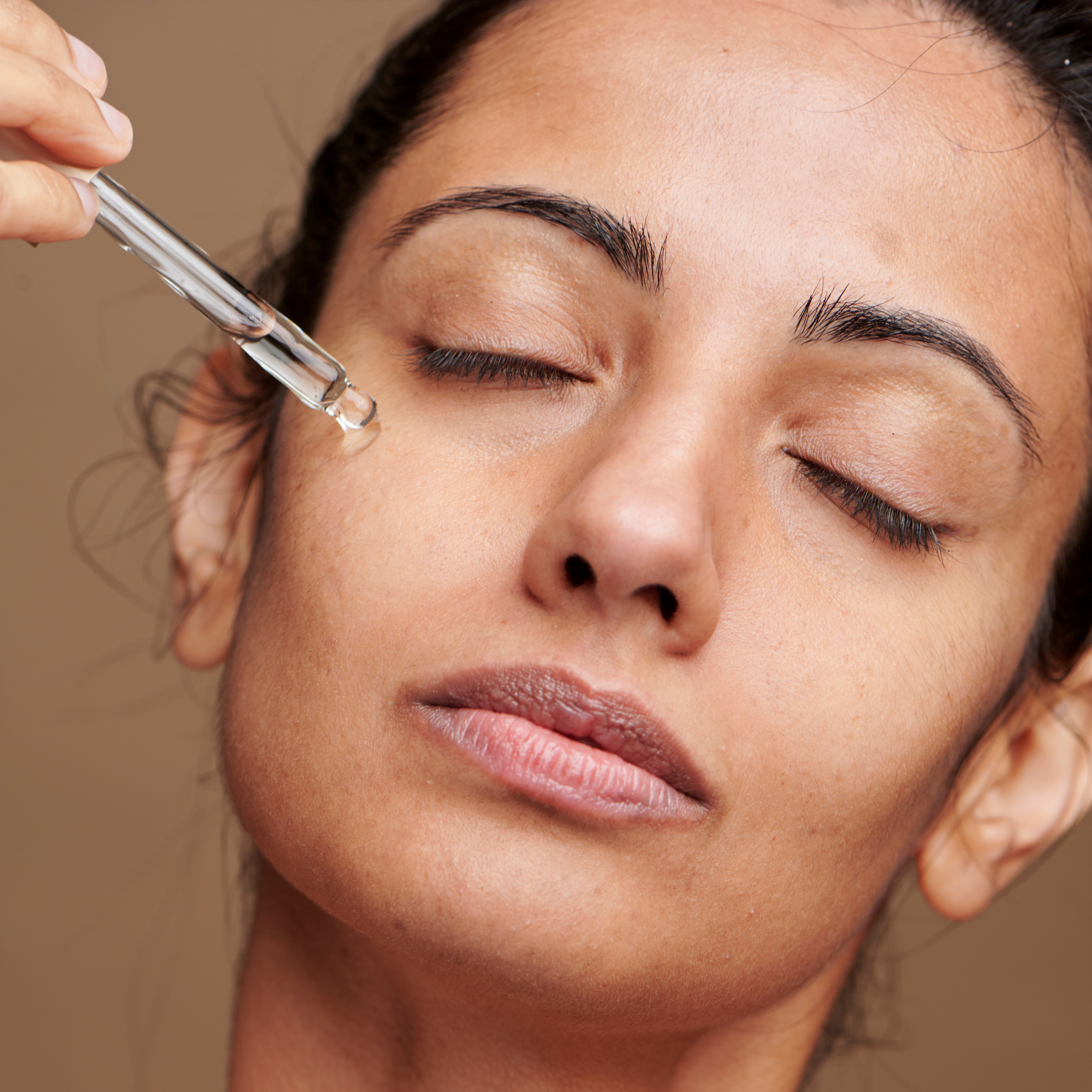 woman applying lactic acid serum aha tonic from skinsetgo on her face